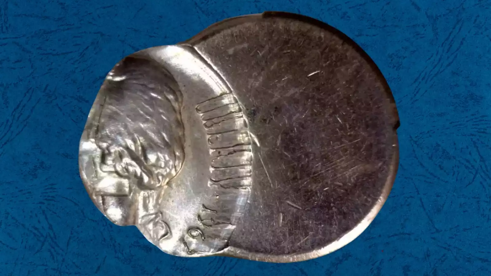 1967 nickel off-center strike error showing crescent blank area and partial Jefferson portrait with visible date